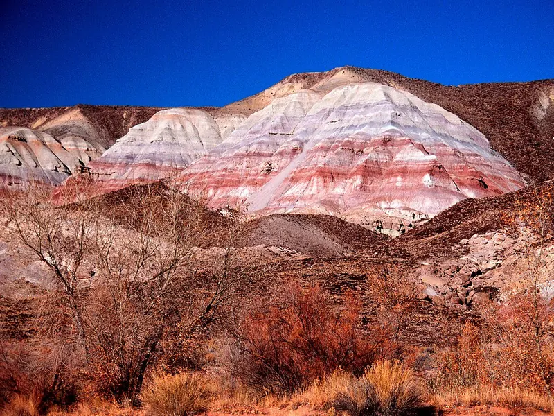 Layers of red, purple and grey rock in a dry hillside